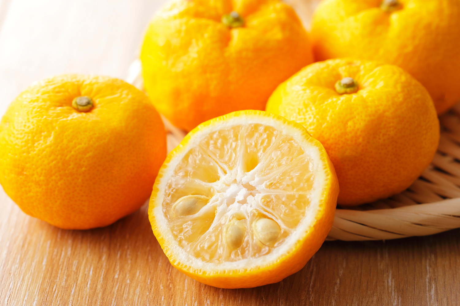 ざるとテーブルの上に置かれたゆず