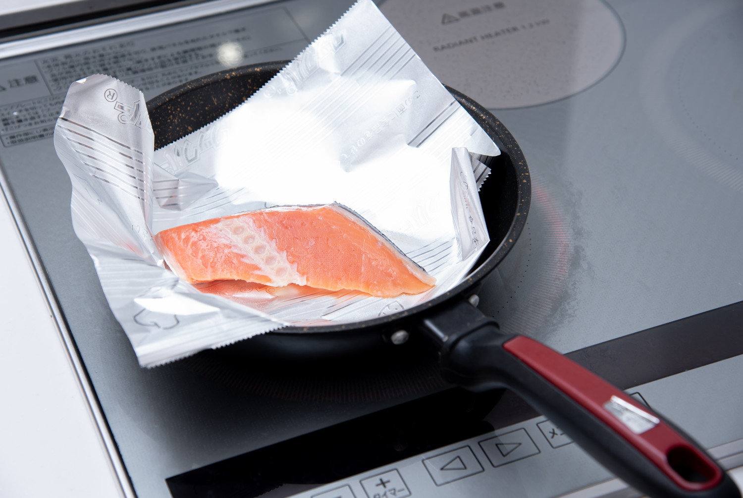 油をひかずに鮭をフライパンで焼いている様子