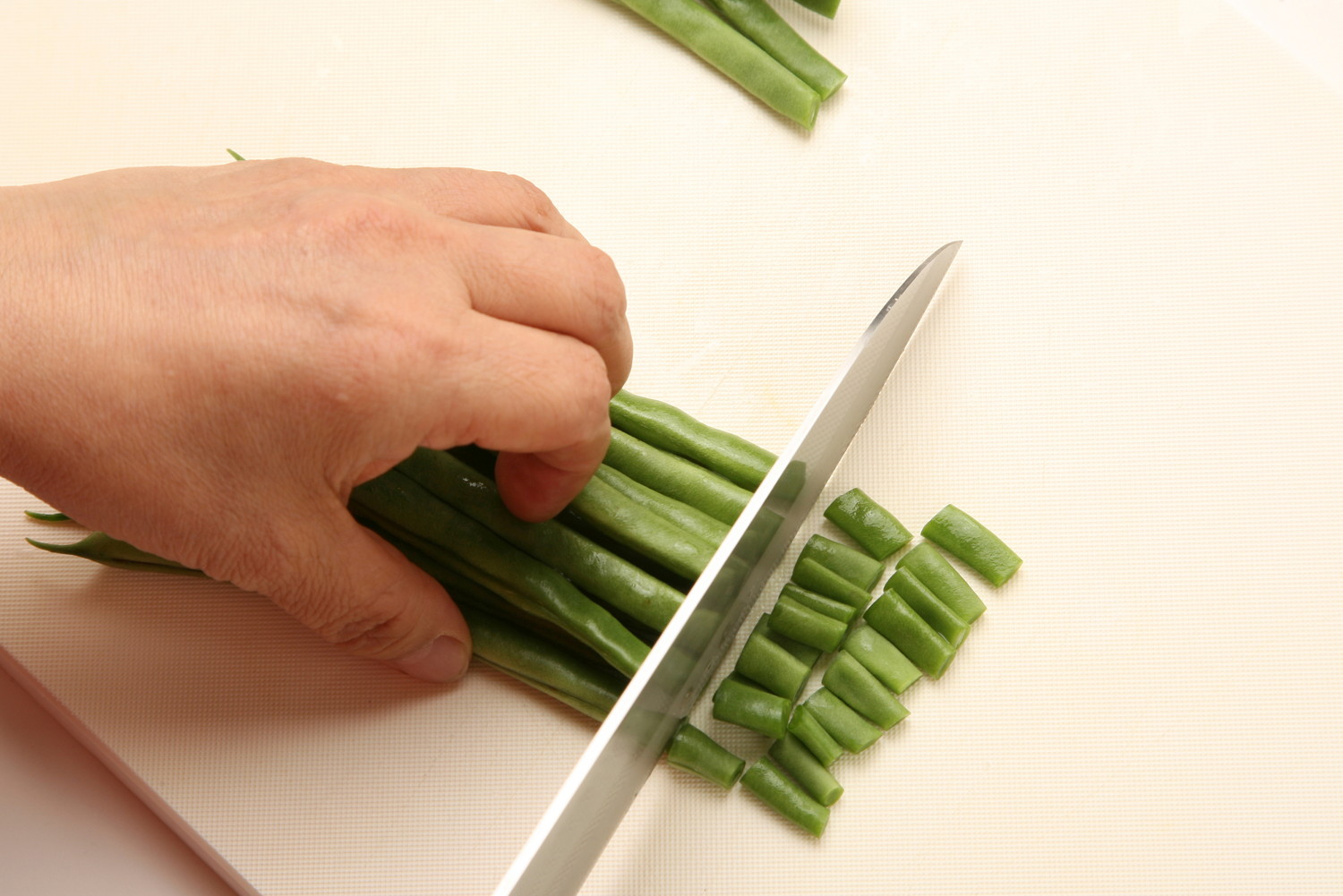 包丁でいんげんを小さくカットしている光景