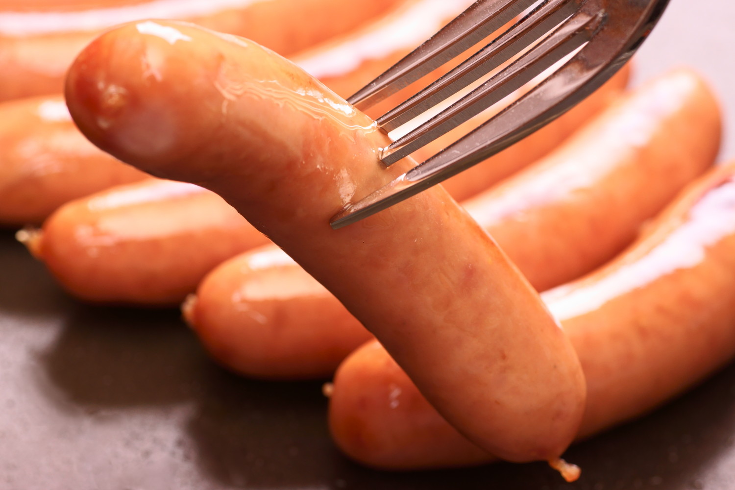 焼いたウインナーをフォークで刺している光景