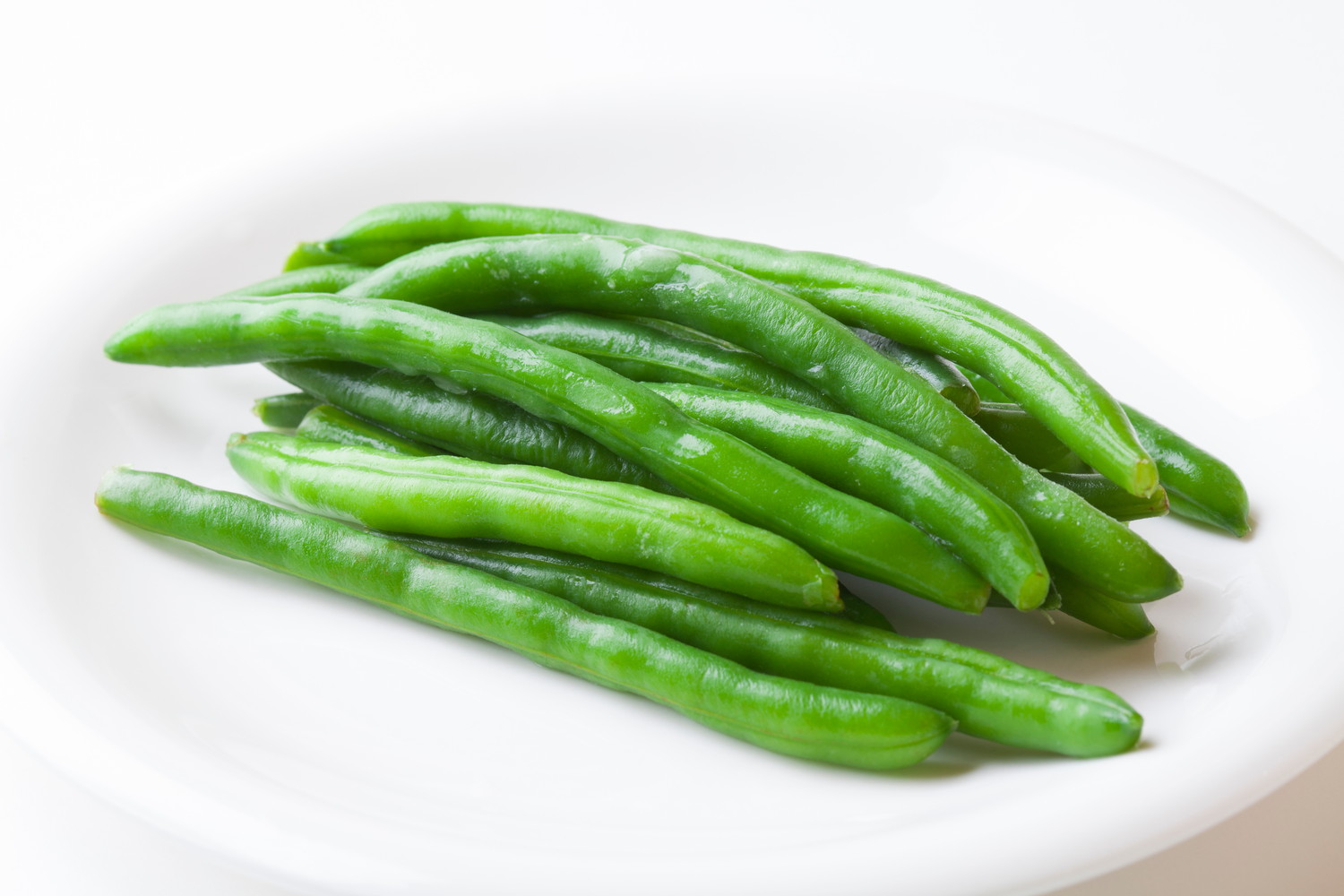 白いお皿にのせられた加熱済みのいんげん