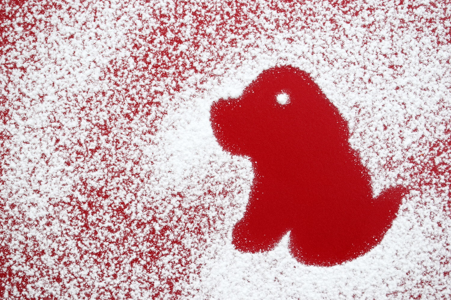 粉砂糖でかたどられた犬のシルエット