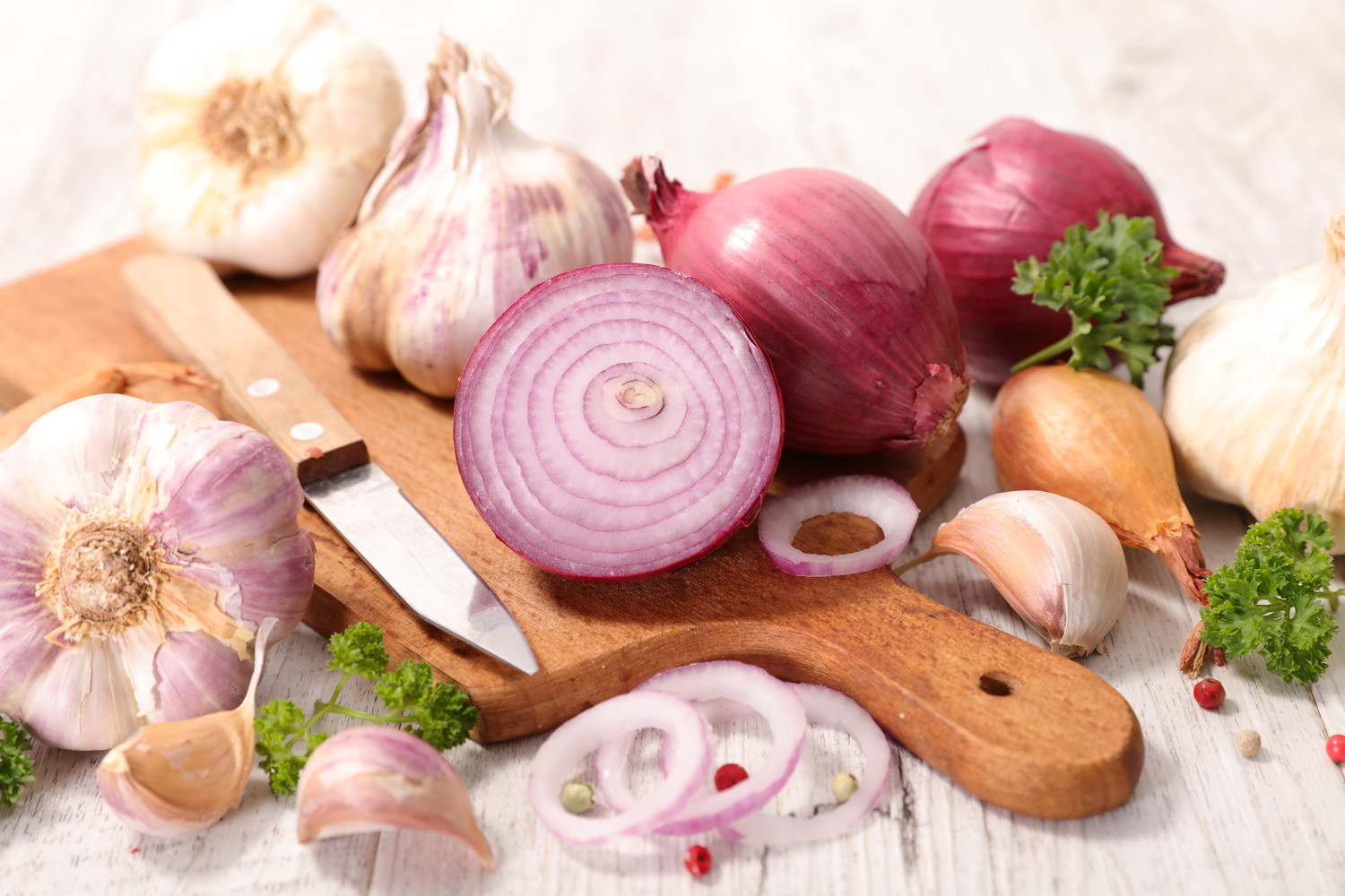 まな板の上に置かれた生の玉ねぎやにんにく