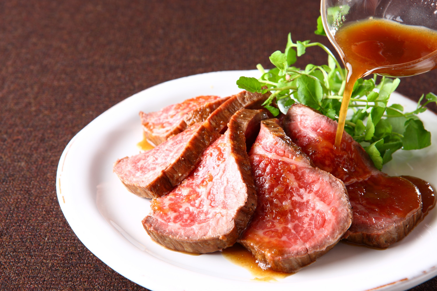 人間用のローストビーフにソースをかけている光景