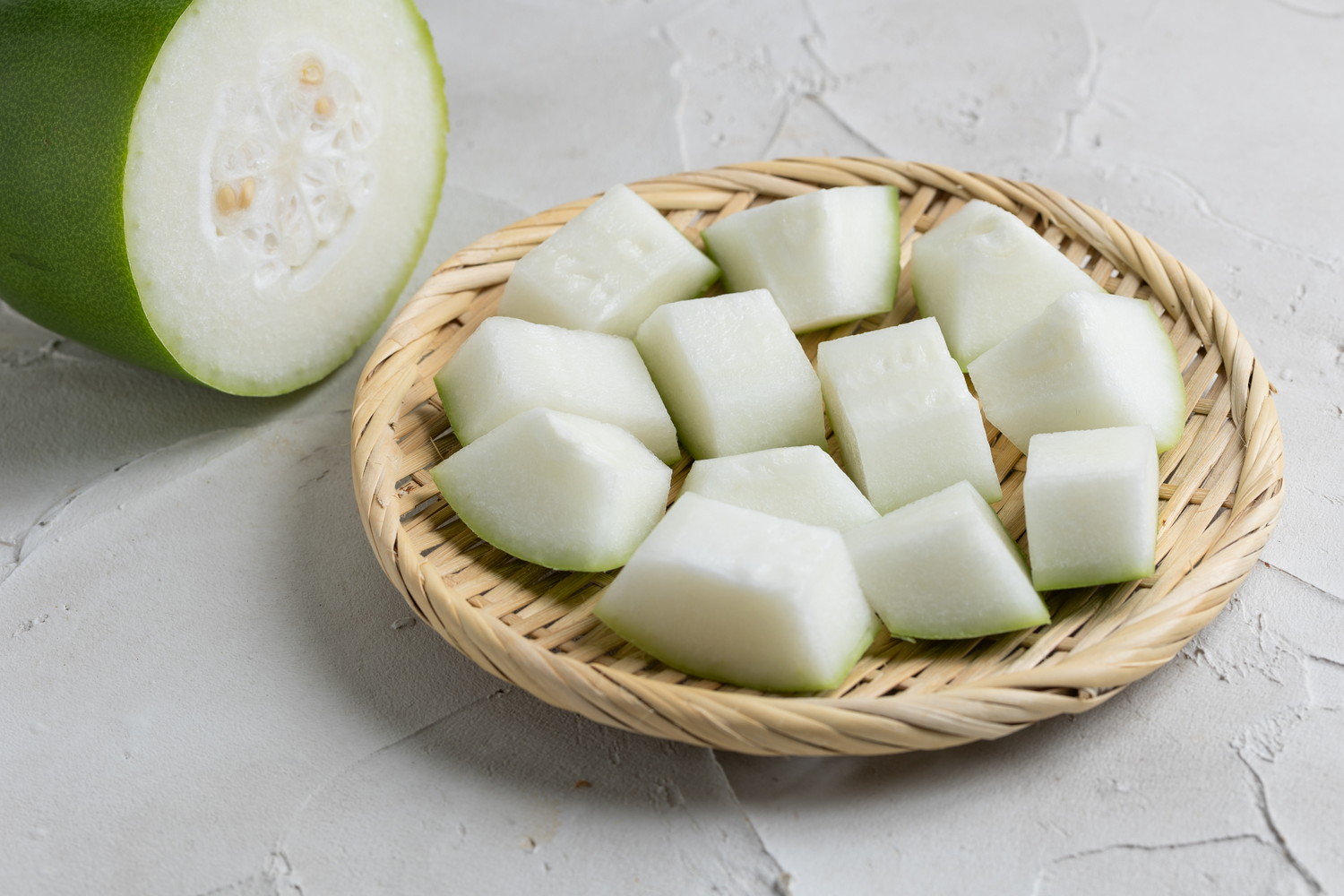 ざるの上にのせられたカット済みの冬瓜