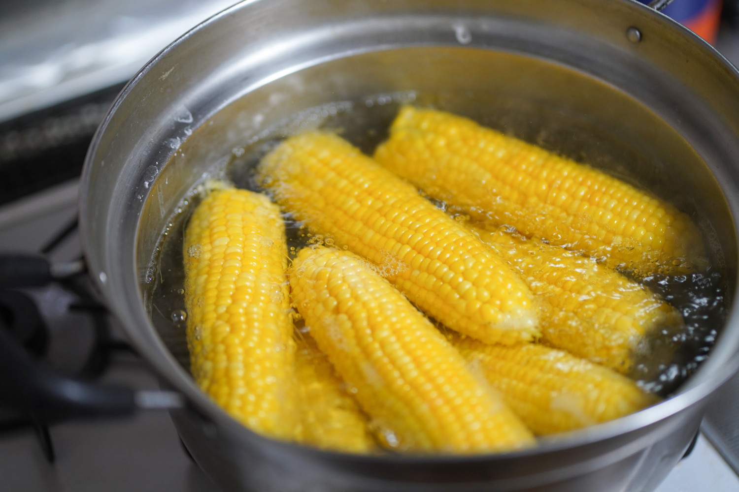鍋でとうもろこしを茹でている様子