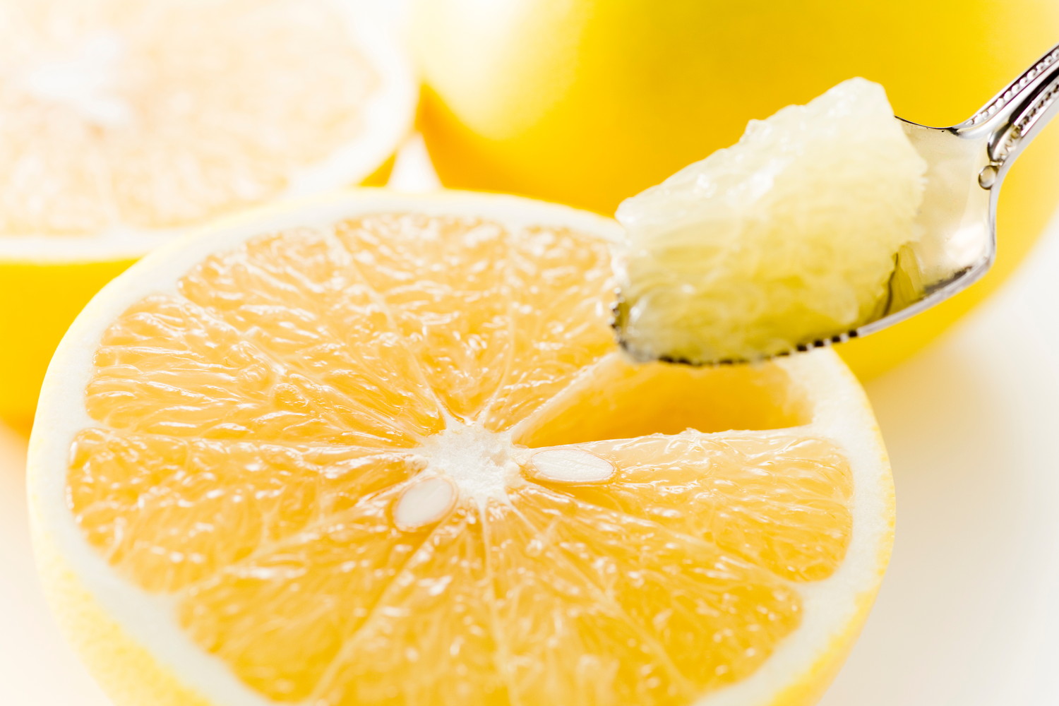 グレープフルーツの果肉をスプーンですくっている様子